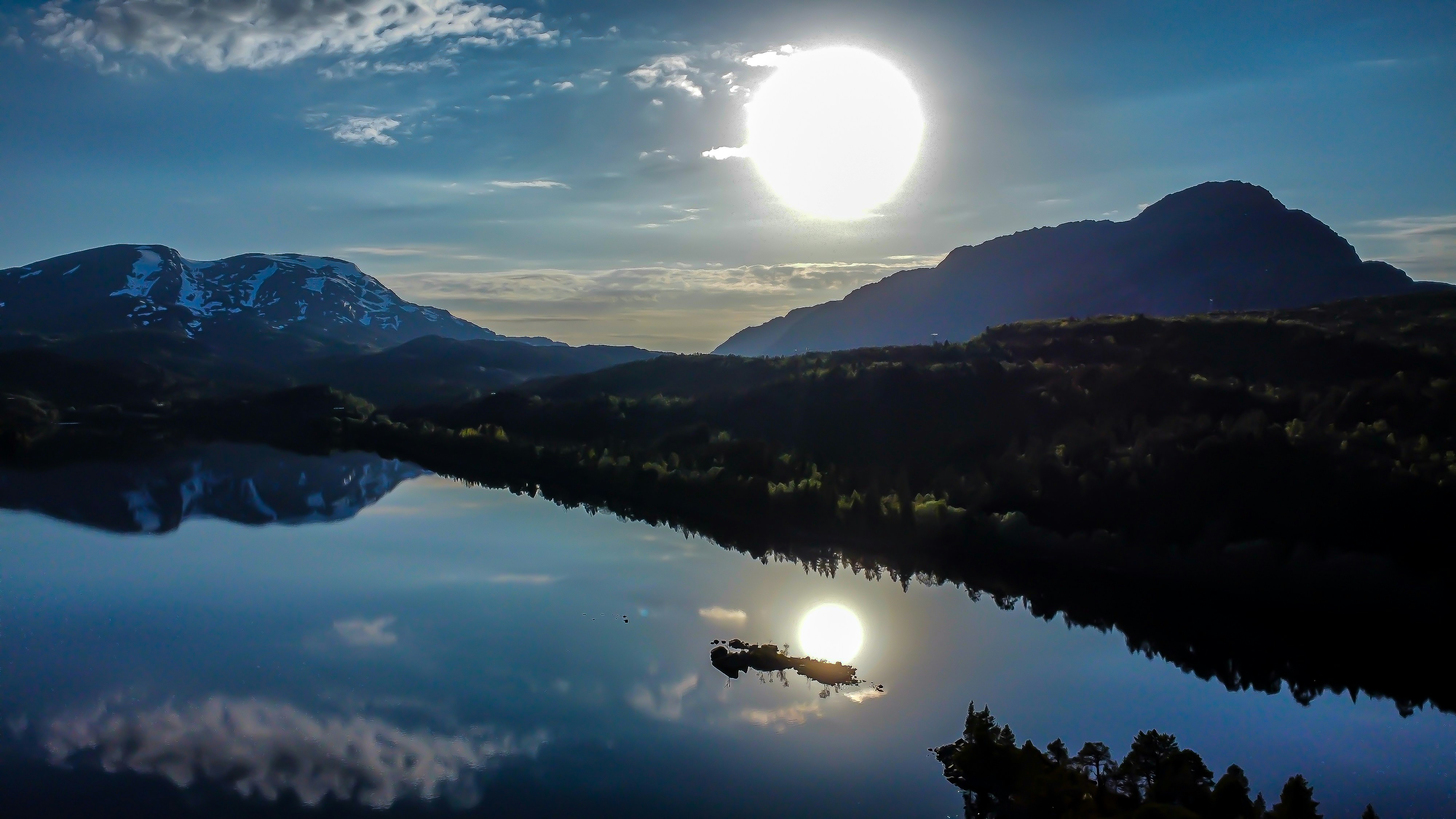 Full moon rising over a lake and mountains